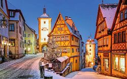 Verschneite Altstadt von Rothenburg ob der Tauber bei Dämmerung.