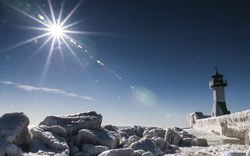 Leuchtturm in Sassnitz auf der Insel Rügen im Winter, umgeben von Eis und Schnee.