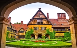 Historisches Gebäude mit Fachwerk und Garten im Vordergrund.