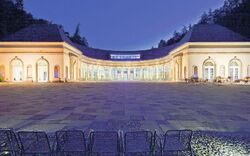 Beleuchtete Wandelhalle in Bad Wildungen bei Dämmerung.