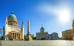 Historischer Platz mit Kirche, Obelisk und blauen Himmel.