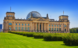 Eine grüne Wiese vor dem Reichstagsgebäude in Berlin.