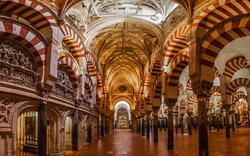 Innenansicht der Mezquita-Kathedrale von Córdoba mit Bögen und Säulen.