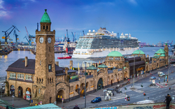 Kreuzfahrtschiff an den Landungsbrücken in Hamburg mit Blick auf historische Gebäude und Hafen.