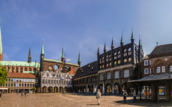 Historische Gebäude am Marktplatz von Lübeck bei klarem Himmel.
