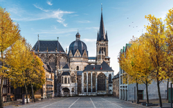 Kirche mit gotischer Architektur und herbstlichen Bäumen im Vordergrund