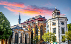 Historisches Gebäude mit einer Kirche und einem Turm bei Sonnenuntergang.