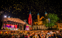 Konzert auf dem Vrijthof-Platz mit Menschenmenge und Konfetti bei Nacht.