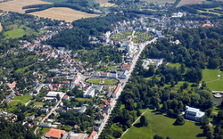 Luftaufnahme einer Stadt mit Grünflächen und Gebäuden.