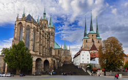 Historische Kirche mit hohen Türmen und blauem Himmel im Hintergrund.