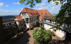 Innenhof der Wartburg mit Fachwerkgebäuden und blauem Himmel.