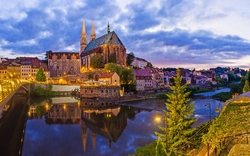 Historische Kirche bei Abenddämmerung mit Spiegelung im Fluss.