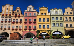 Bunte historische Gebäude an einem Marktplatz bei sonnigem Wetter.