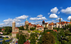 Panorama einer historischen Stadt mit Türmen und Brücke bei klarem Himmel.