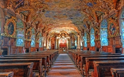 Barocker Kircheninnenraum mit verzierten Wänden und Deckenfresken.