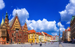 Historischer Marktplatz mit bunten Gebäuden und blauem Himmel.