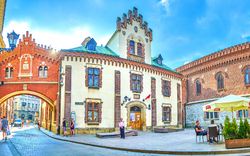 Historischer Gebäudekomplex mit Torbogen und gepflasterter Straße.