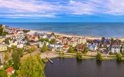Luftaufnahme einer Küstenstadt mit Stränden und Meer im Hintergrund.