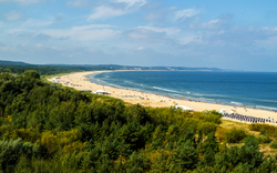 Strandansicht von Swinemünde an der polnischen Ostseeküste mit Sandstrand und Meer im Hintergrund.