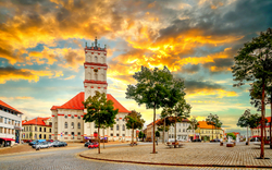 Historischer Marktplatz mit Kirche bei Sonnenuntergang.