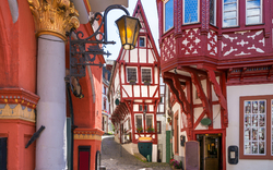 Fachwerkhäuser in einer engen, malerischen Altstadtgasse bei Tageslicht.