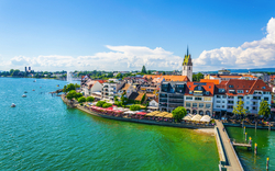 Blick auf eine Stadt am Bodensee mit Hafen und historischen Gebäuden.