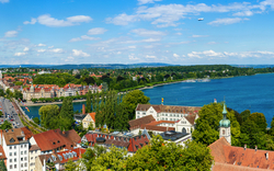 Panorama von Konstanz am Bodensee, mit Blick auf die Stadt und den See unter blauem Himmel.