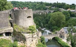 Wehranlage auf dem Bockfelsen in Luxemburg mit grüner Umgebung und Brücke.