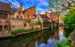Kanal mit historischen Gebäuden und Bäumen in einer europäischen Stadt.