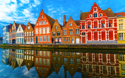 mittelalterliche Gebäude entlang eines Kanals in Brügge, Belgien, mit ihrer Spiegelung im Wasser