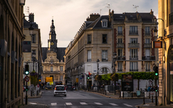Straßenansicht mit Autos und historischen Gebäuden bei Sonnenuntergang.