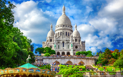 Blick auf die Basilika Sacré-Cœur in Paris, mit Karussell im Vordergrund.