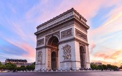 Triumphbogen in Paris bei Sonnenuntergang, mit rosa und blauem Himmel.