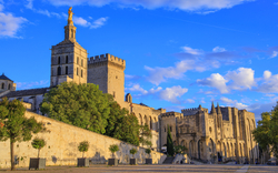 Historischer Papstpalast mit mittelalterlicher Architektur und blauen Himmel in Avignon.