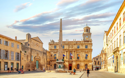 Historischer Platz mit Obelisk und alten Gebäuden bei Sonnenuntergang.