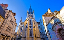 Gotische Kirche in einer Altstadt bei klarem Himmel.
