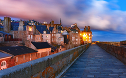 Historischer Stadtkern von Saint-Malo in der Bretagne bei Dämmerung, umgeben von Festungsmauern.