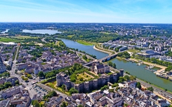 Luftaufnahme einer Stadt mit Fluss, Brücke und historischen Gebäuden.