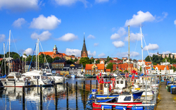 Hafenstadt mit Segelbooten und rotem Ziegeldach in der Sonne