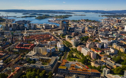 Luftaufnahme einer Stadt mit Hafen und umliegender Landschaft.