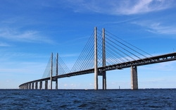 Lange Brücke über Wasser bei klarem Himmel.
