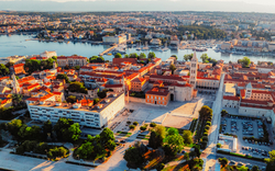 Luftaufnahme einer Küstenstadt mit historischen Gebäuden und Meeresblick.