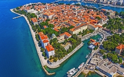 Luftaufnahme von Zadar, Kroatien, mit roten Dächern und blauem Meer.