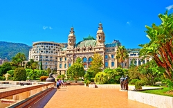 Eindrucksvolles Gebäude mit Gartenanlage und Menschen im Vordergrund bei sonnigem Himmel.