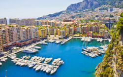 Blick auf den Hafen von Monte Carlo in Monaco mit Yachten und umliegender Architektur.