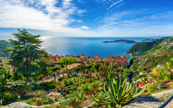 Aussicht auf eine Küstenlandschaft mit blauem Meer und grüner Vegetation.
