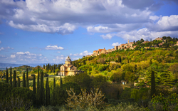 Kirche San Biagio und das mittelalterliche Dorf Montepulciano in der toskanischen Hügellandschaft.