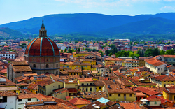 Kuppel eines Doms in einer italienischen Stadt mit Hügeln im Hintergrund