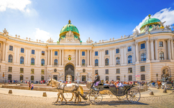 Die Hofburg in Wien mit einer Pferdekutsche auf dem Heldenplatz.