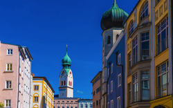 Farbenfrohe Altstadt mit Kirchturm und blauen Himmel im Hintergrund.
